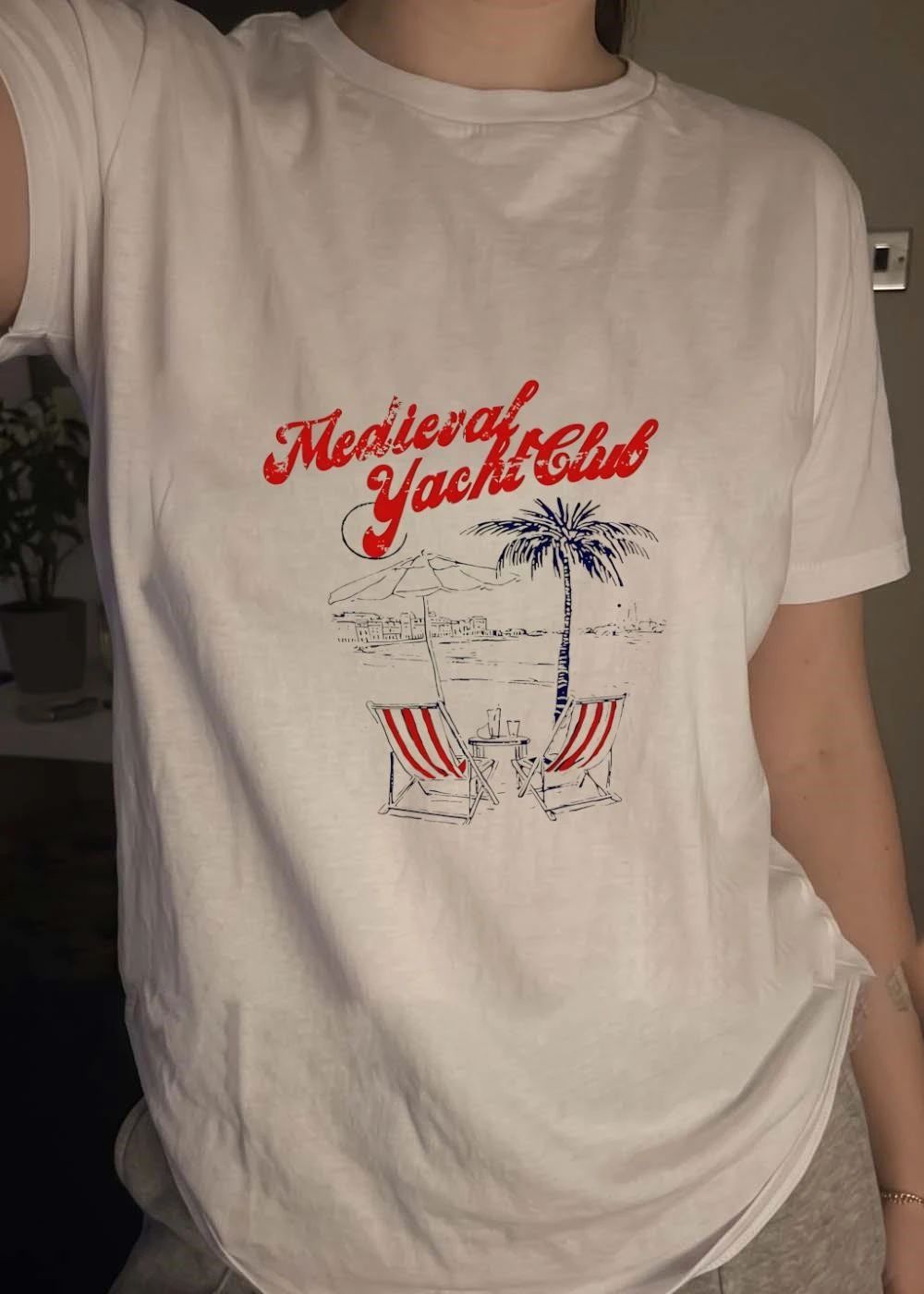 Relaxing Beachfront Oasis with Striped Lounge Chairs and a Palm Tree Medieval Yacht Club T-Shirt
